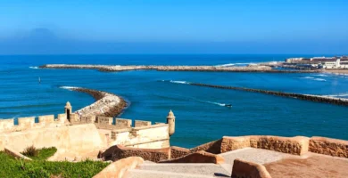 Imagen de la Playa de Rabat con el sol brillando sobre la arena dorada y el mar atlántico en el horizonte